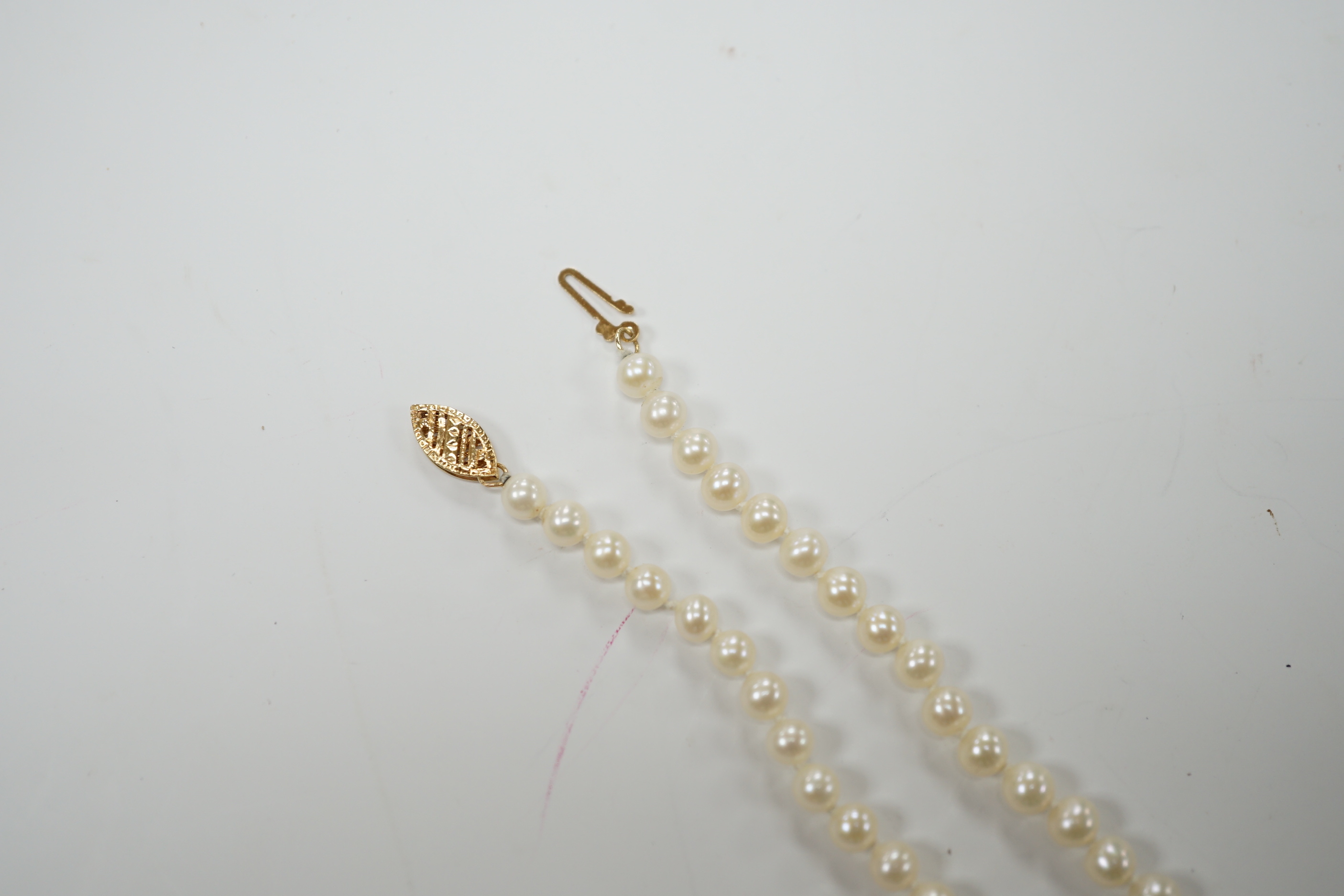 A modern single strand cultured pearl necklace, with central diamond chip set 14k yellow metal twin hearts motif, 42cm, gross weight 15.2 grams.